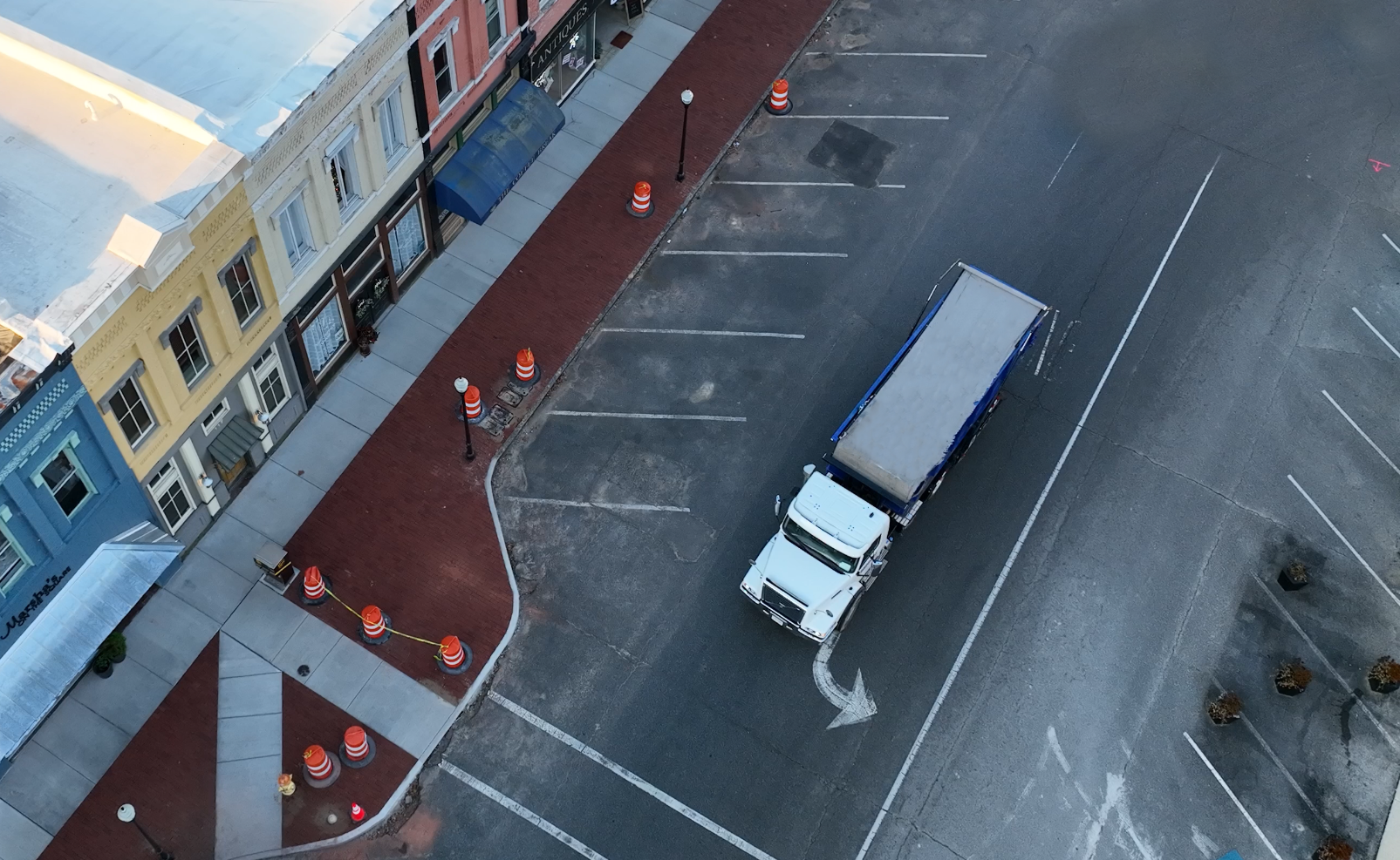 A Jones Logistics roll-off dedicated truck makes a right turn on the road.