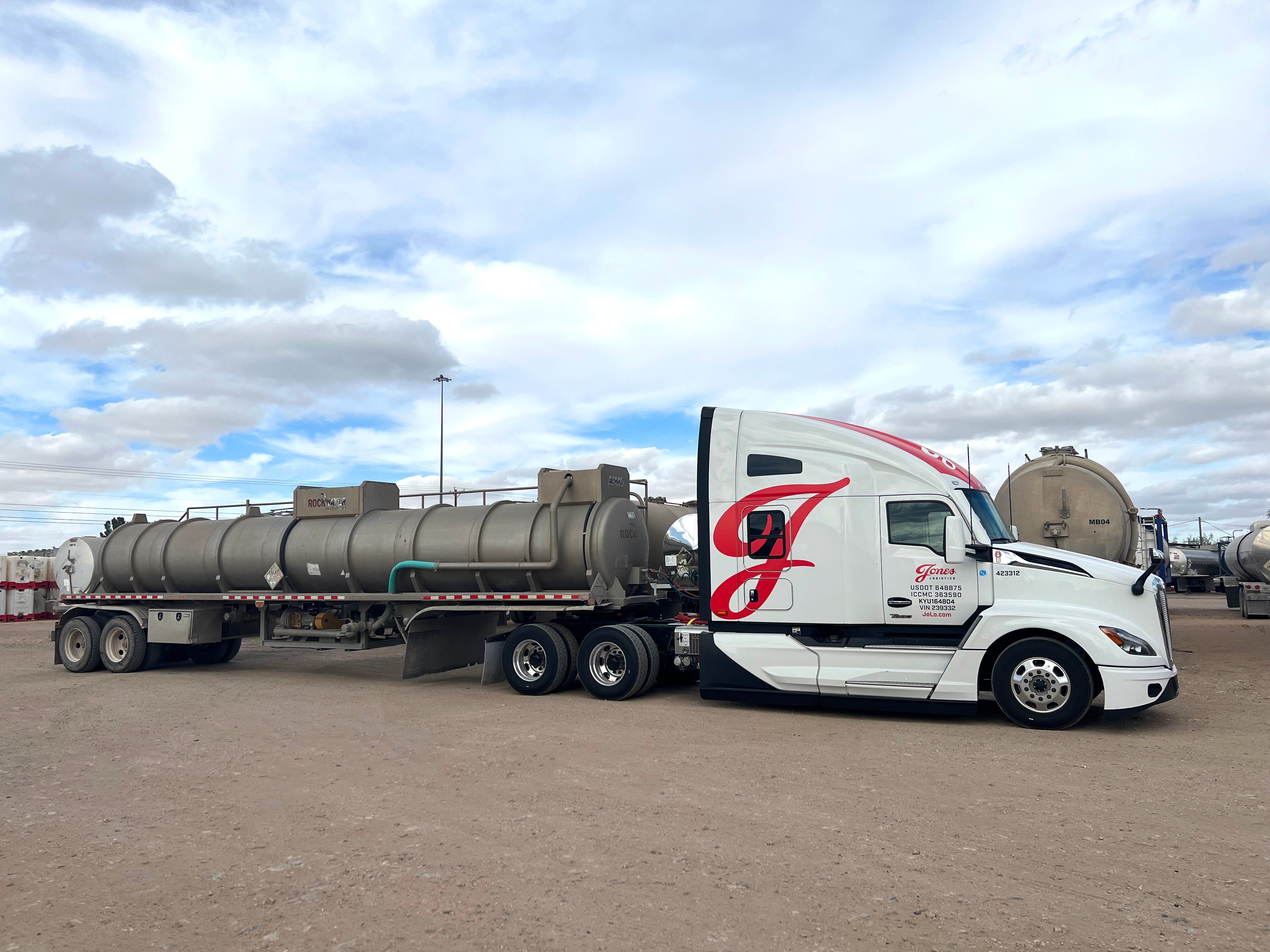 A Jones Logistics (JoLo) dedicated, open-deck truck hauls a tank to an offsite location.